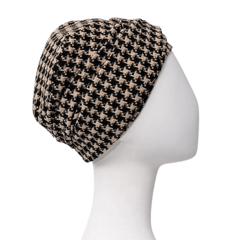 Lea turban i sort og beige houndstooth-mønster set fra siden på mannequin, med fokus på fylden