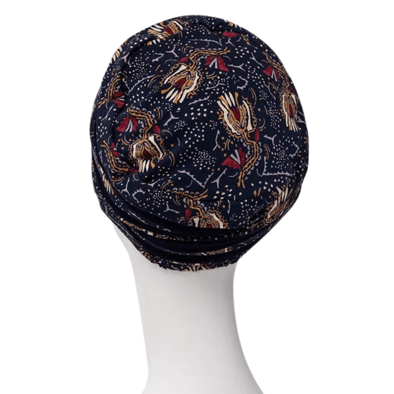 Shanti turban i Amber Garden print set bagfra på en hvid mannequin, med det mørkeblå fjer- og stammemotiv