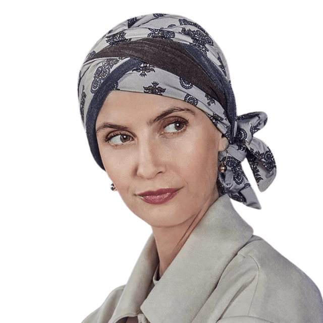 Kvinde med Beatrice turban i paisley-mønster med beige, brun og blå nuancer, bindebånd i siden