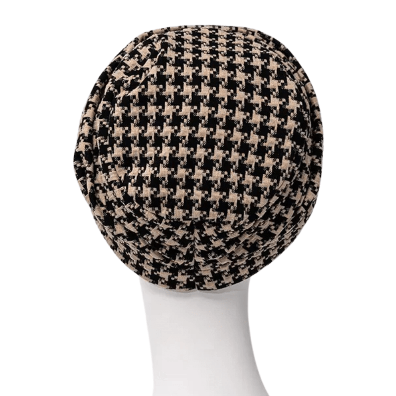 Lea turban i sort og beige houndstooth-mønster set bagfra på en hvid mannequin, med let baggy-effekt