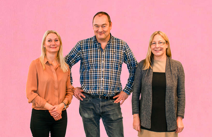 3 glade medarbejdere står og smiler