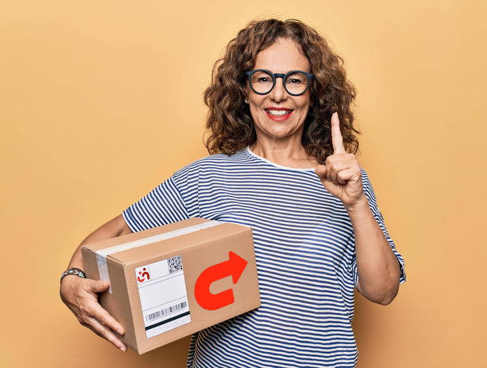 Kvinde står med en pakke som skal sendes retur