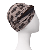 Shakti turban i beige med mørkt paisley-mønster, set fra højre side på mannequin med knold i nakken
