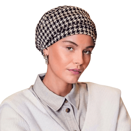 Lea turban i sort og beige houndstooth-mønster båret af en kvinde forfra, med elegant volumen