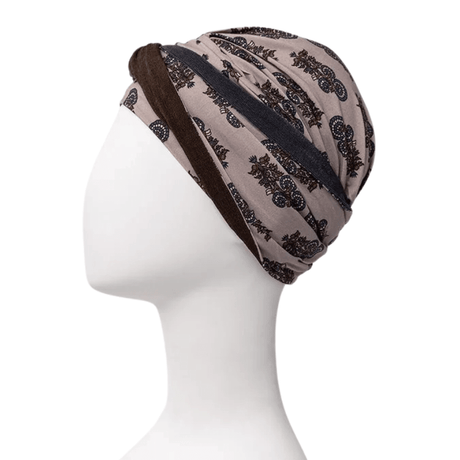 Shakti turban i beige med mørkt paisley-print, set fra siden på mannequin, pandebånd langs nakken