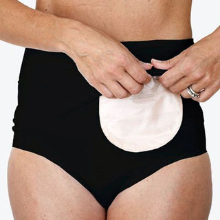 Sort StomiFix stomibælte båret af person, der holder op i kanten for at vise den beige stomipose